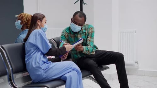 Doctor Speaking with Patient in Hospital Waiting Room