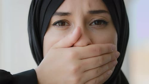 Distressed Woman in Hijab Covers Her Mouth