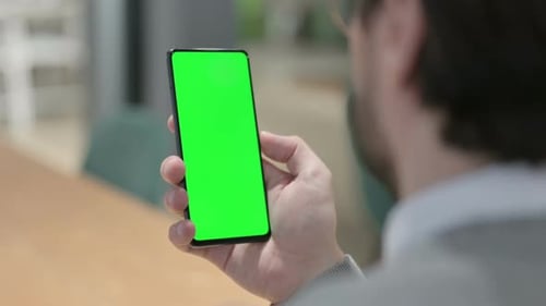 Man Looking at Smartphone with Green Chroma Screen