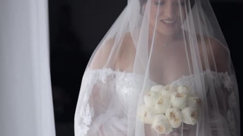 Elegant Bride Holds Bouquet of White Roses