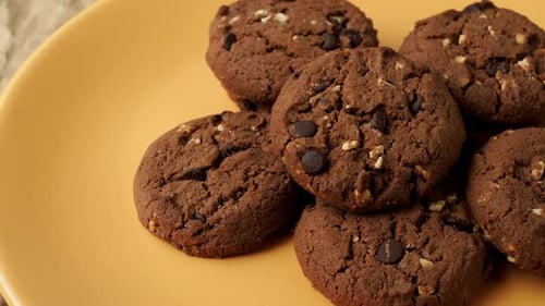 Chocolate Chip Cookies Piled High on a Yellow Plate
