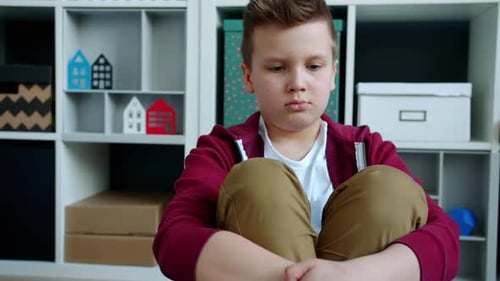 Depressed Child Sitting on Floor Feeling Sad Sighing and Having Nothing To Do During Lockdown