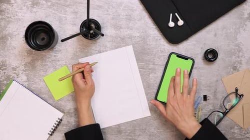 Woman writing notes with pen on paper, top view of office work desk