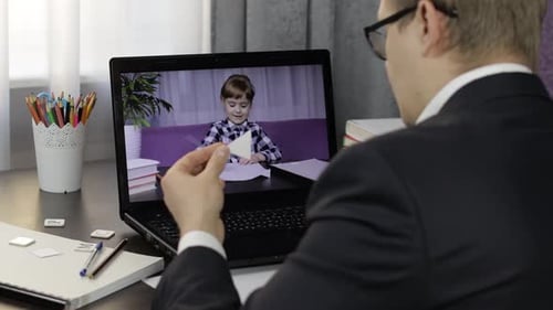 Man Works Remotely while Talking to Child Online
