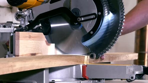 Nahaufnahme einer stationären Kreissäge beim Sägen eines Holzes in einer Schreinerei