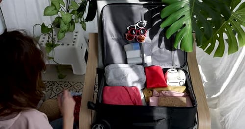 Woman Packing Clothes in Preparation for Travel