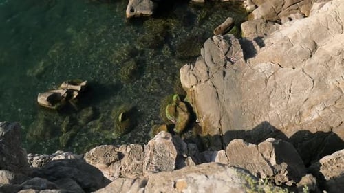 Top View of the Waves Crashing Against Rocks in the Blue Ocean