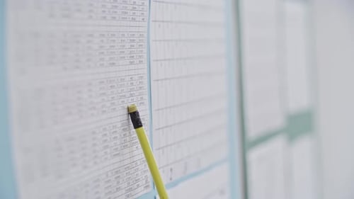 Hand Points to Document with Yellow Pencil