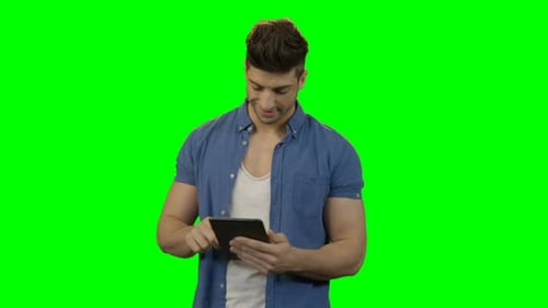 Young Adult Interacting with Tablet on Green Screen