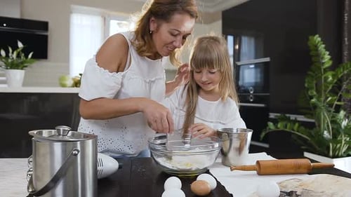 Mother and Daughter Baking Together in Kitchen