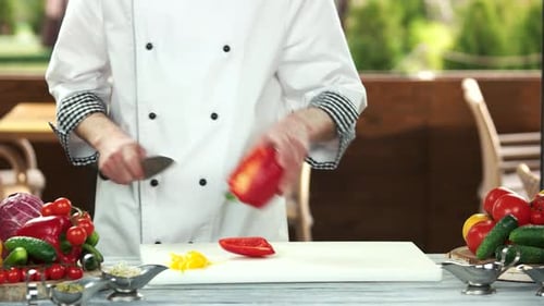 Chef cortando pimentón rojo.
