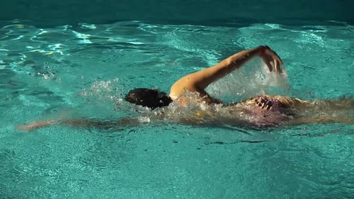 Woman Swimming Laps in a Bright Tropical Pool