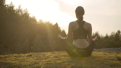 Woman Meditating at Sunrise in Nature