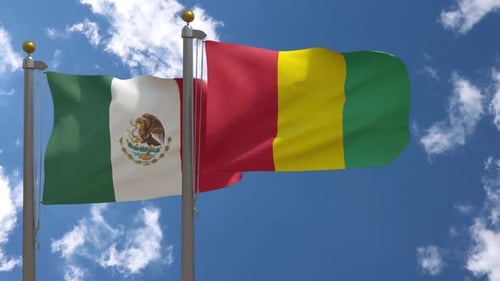 Mexican and Guinea Flags Waving Realistically on Flagpoles