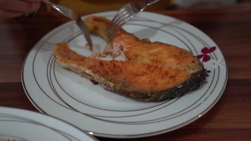 Cutting Tasty Pan-Fried Fish with Forks
