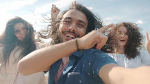 Joyeux homme du Moyen-Orient dansant pendant une partie de plage s'amusant avec des amis le jour d'été