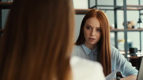 Rückansicht einer Bewerberin während des Vorstellungsgesprächs im Gespräch mit jungen Arbeitgeberinnen