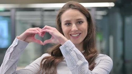 Woman Makes Heart Shape with Hands and Smiles