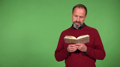 A Middleaged Handsome Caucasian Man Reads a Book Green Screen Background