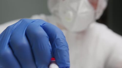 PCR Test in Laboratory Doctor Holding COVID19 Coronavirus Swab Collection Kit Wearing PPE Protective