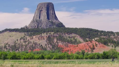 Blick auf den Devils Tower über das Feld, während in Wyoming Gras im Wind weht