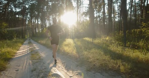 Young Sportsman Doing Evening Cardio at Green Forest