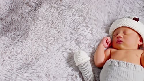 Sleeping Baby in Knit Cap on Soft Blanket