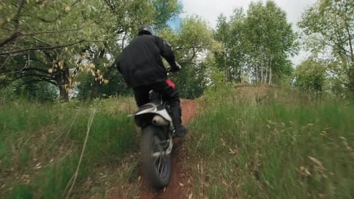 Motorcyclist Racing through Forest
