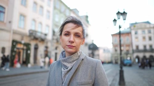Portrait of a Caucasian Woman in a Coat in the Middle of the Old City Square