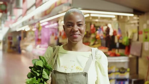 Mujer sonriente con bolsa de compras en un mercado
