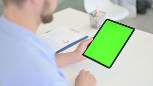 Man Holding Tablet with Green Screen in Office