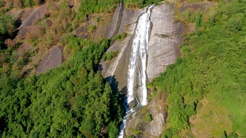 Waterfall on a rock in the mountain with trees