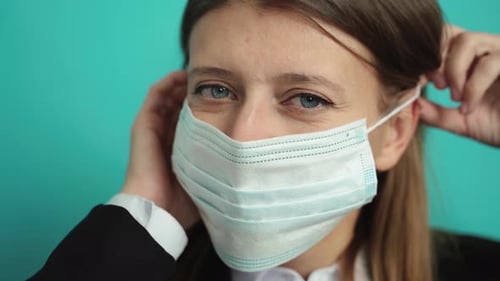 Woman Puts on Protective Surgical Mask on Face