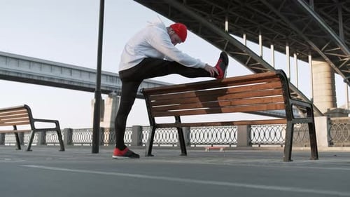 Stretch Man Training Urban. Young Flexible Male Stretches Deeply in Urban City Surroundings, in Slow