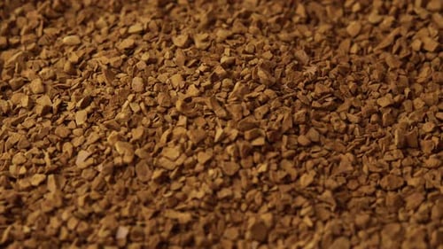 Granules of Instant Coffee Sprinkled on a Plate Closeup Spinning As a Backdground for a Coffee Shop