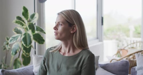 Frau niest zu Hause auf den Ellbogen
