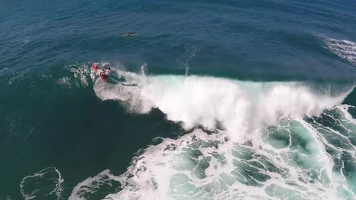 Aerial view of a man sup stand-up paddleboard surfing in Hawaii
