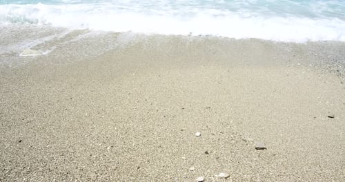 Close Up of Foaming Waves and Splashes on Sandy Beach Sunshine