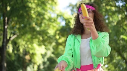 Stylish Woman Posing with Banana in the Park