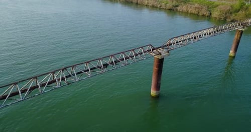 Altes Metallrohr läuft über einen Fluss