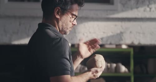 Male Artisan Slapping and Kneading Clay