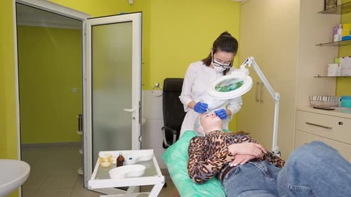 Cosmetologist Performing Skincare Treatment in Bright Medical Office