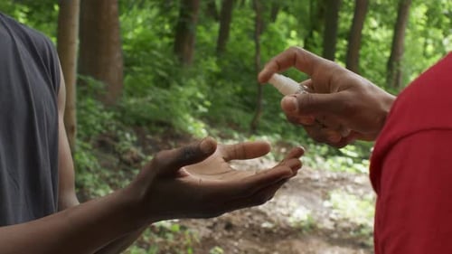 Hand Sanitizer Application in Lush Green Forest