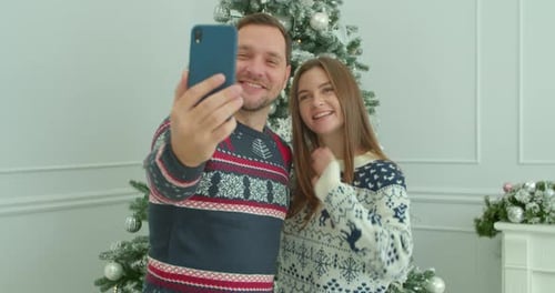 Cheerful Couple Taking Selfie at Christmas Time