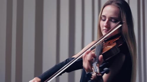 Girl Violin Playing at Studio. Woman Is Practicing Playing Musical Instrument