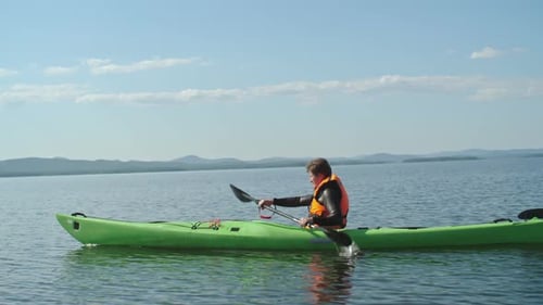 Man Kayaking on Lake on Sunny Day