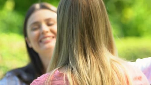 Women Friends Reunite and Embrace in a Park