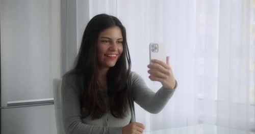 Happy Woman Video Chatting on Phone Indoors