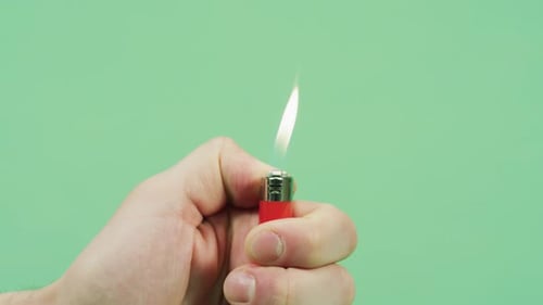 Hand Lighting Red Lighter with Bright Flame