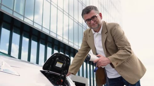 Man Charging Electric Car in Urban Setting
